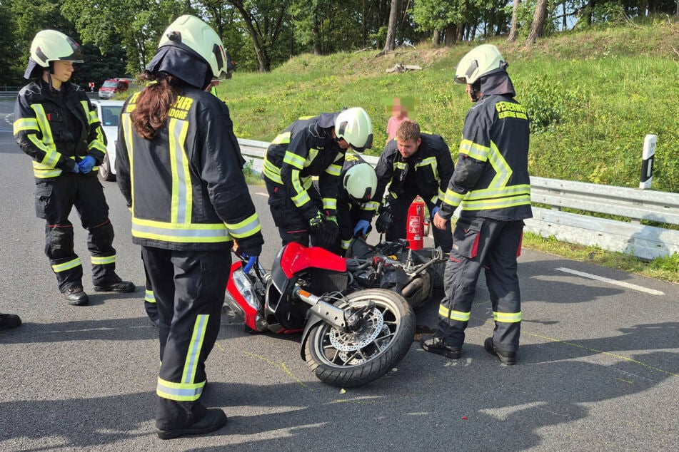 Einsatzkräfte der Feuerwehr untersuchen die Maschine der Bikerin.