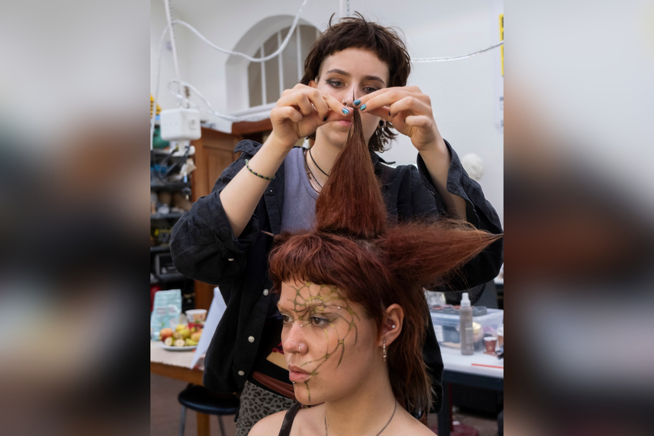 Eine Studentin der Klasse Maskenbild bereitet 2023 ihre Arbeit für die Werkshow Theaterdesign vor.