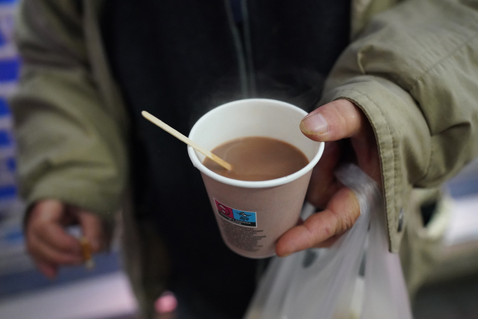 Eine obdachlose Frau hält einen Kaffee in der Hand. Für Menschen ohne Übernachtungsgelegenheit gibt es das Winternotprogramm.