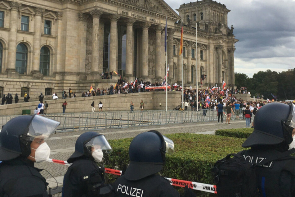 Teilnehmer einer Kundgebung gegen die Corona-Maßnahmen stehen am Samstag vor dem Reichstag.