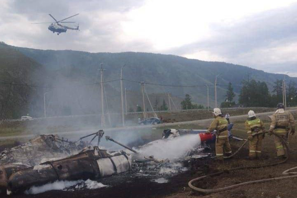 Feuerwehrmänner löschten den abgestürzten Hubschrauber mit Schaum.