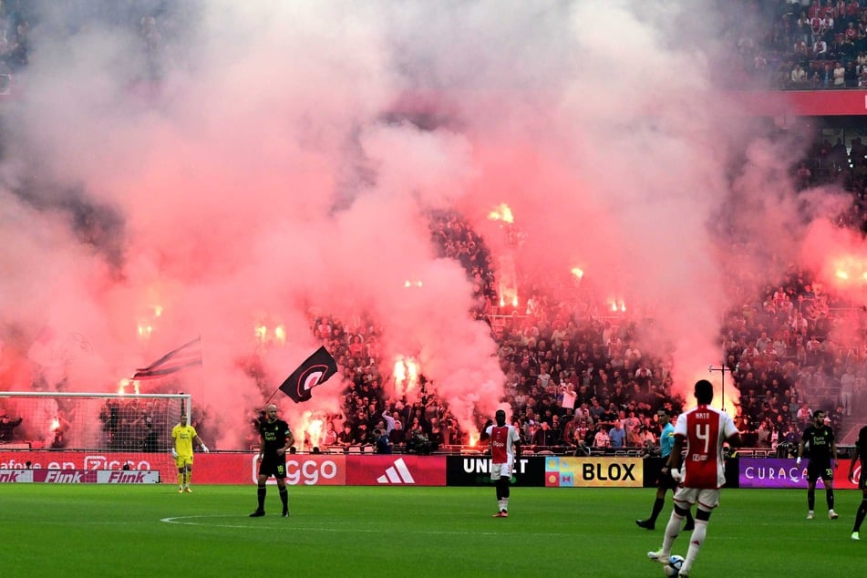 Beim Spiel Ajax Amsterdam gegen Feyenoord Rotterdam am 24. September 2023 zünden Fans von Ajax Pyrotechnik.