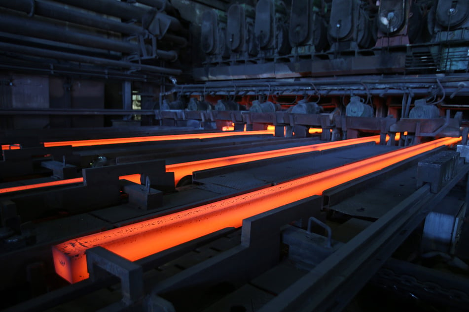Glühende "Stahlknüppel" laufen auf der Gussanlage in der Stahlwerkshalle von ArcelorMittal in Hamburg. (Archivbild)