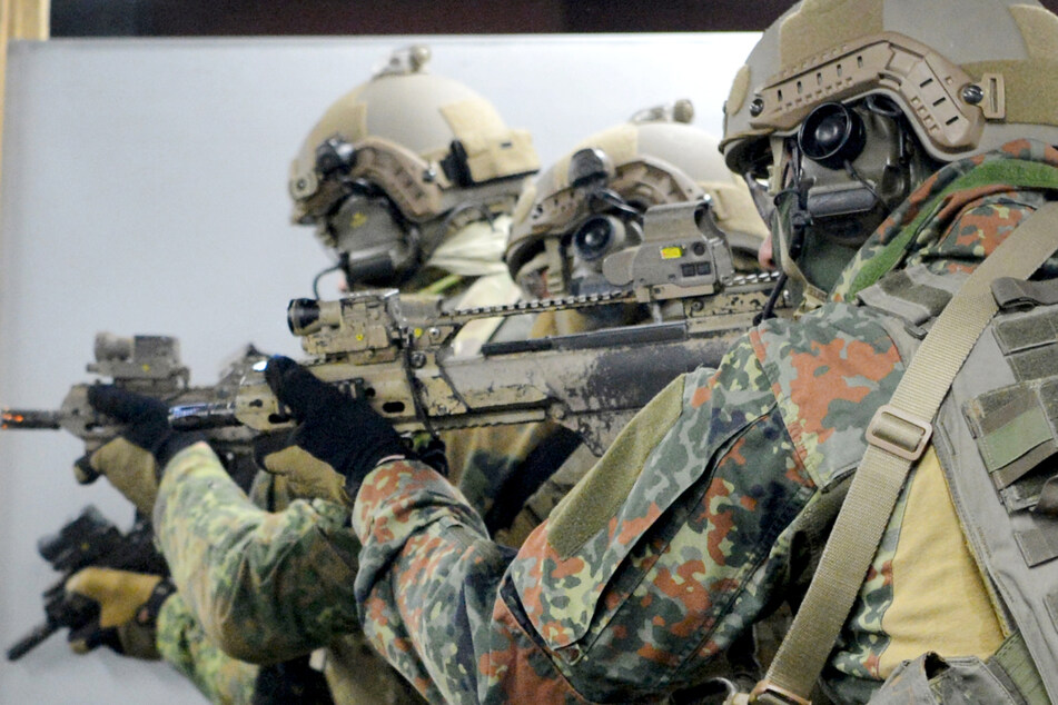 Soldaten trainieren mit Gewehren auf einem Gelände.