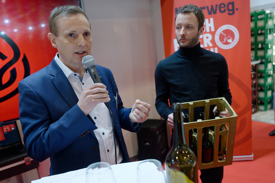 Werner Bender (l), Vorstand der Wein-Mehrweg eG, und Patrick Hilligardt, Vorstandssprecher der Weinheimat Württemberg eG, stellen die neue 0,75 Liter Mehrwegflasche vor.