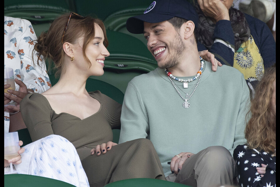 Phoebe Dynevor (l.) and Pete Davidson share loving stares at Wimbledon in London, United Kingdom.
