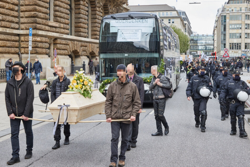Die "Querdenker" tragen in Hamburg symbolisch die Demokratie zu Grabe.