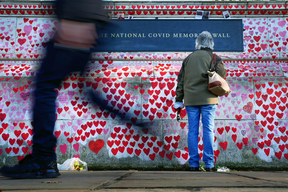 Eine Frau hält inne und liest die Widmungen an der National Covid Memorial Wall in Westminster. Boris Johnson plant ein Ende der Isolationspflicht für Infizierte. Das könnte der Wall weitere Namen bescheren.