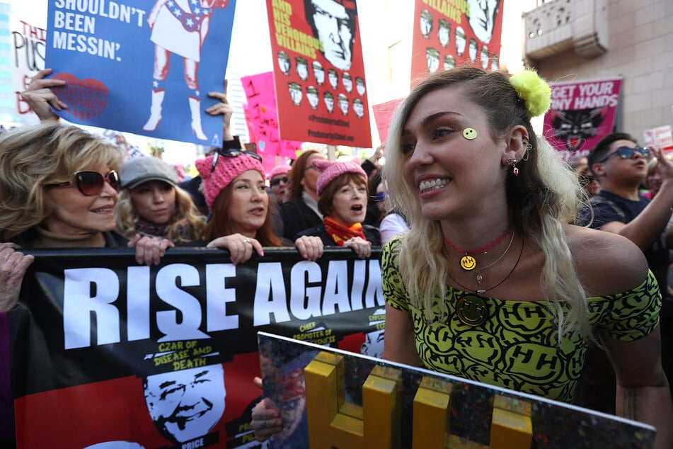 Singer Miley Cyrus (r.) marches during the Women's March on January 21, 2017 in Los Angeles, California. Ten of thousands of people took to the streets of Downtown Los Angeles for the Women's March in protest after the inauguration of President Donald Trump.