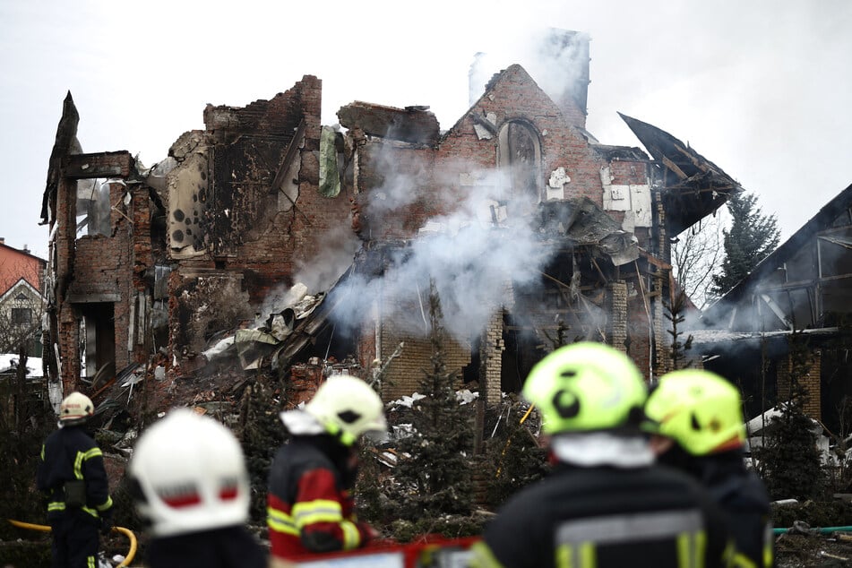 Ukrainian rescuers stand next to a heavily damaged house following an air attack in Sofiivska Borshchagivka, Kyiv region, on February 22, 2026.