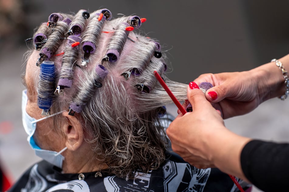 Einer Kundin werden in einem Friseursalon die Haare frisiert (Symbolbild).