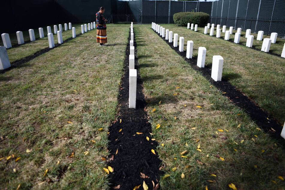 An Indigenous woman pays respects to children buried at Carlisle Barracks Post Cemetery.