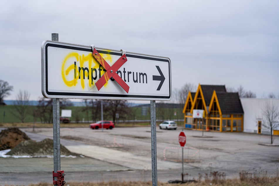 Auf die Wegweiser zum Impfzenturm wurde mit gelber Farbe "Gift" geschrieben.