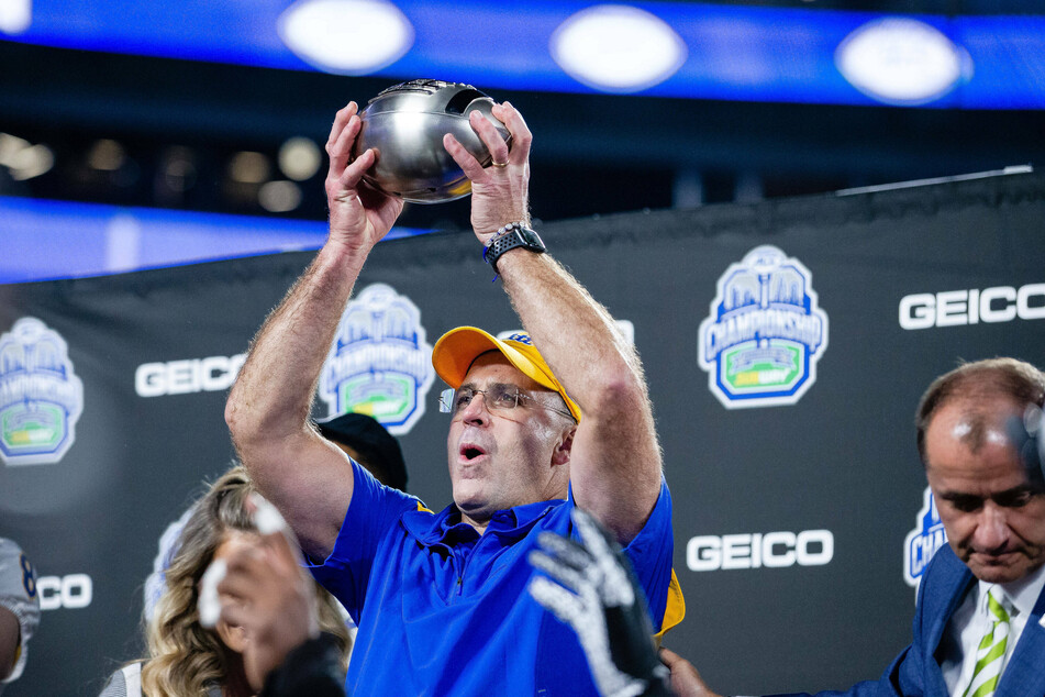 Pittsburgh Panthers head coach Pat Narduzzi held up the ACC Championship trophy.