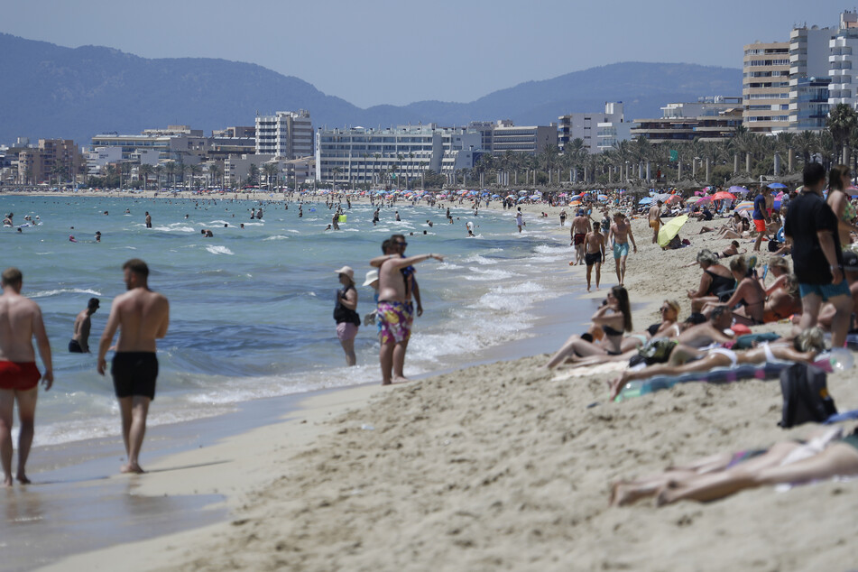 Touristen am Strand von Arenal in Palma de Mallorca.