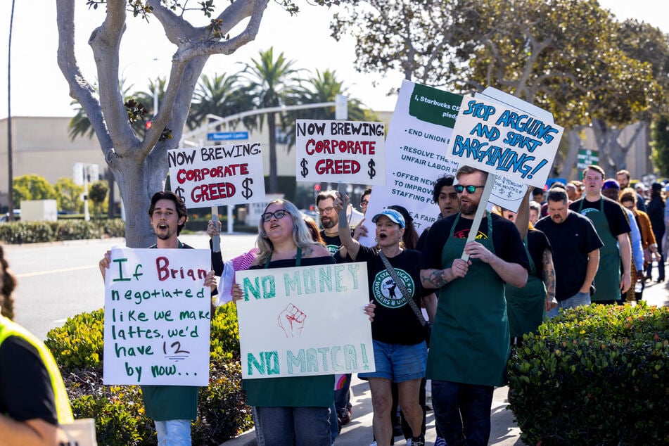 Starbucks baristas and supporters march to the company's corporate offices as part of a nationwide push for improved wages and working conditions in Newport Beach, California, on November 24, 2025.