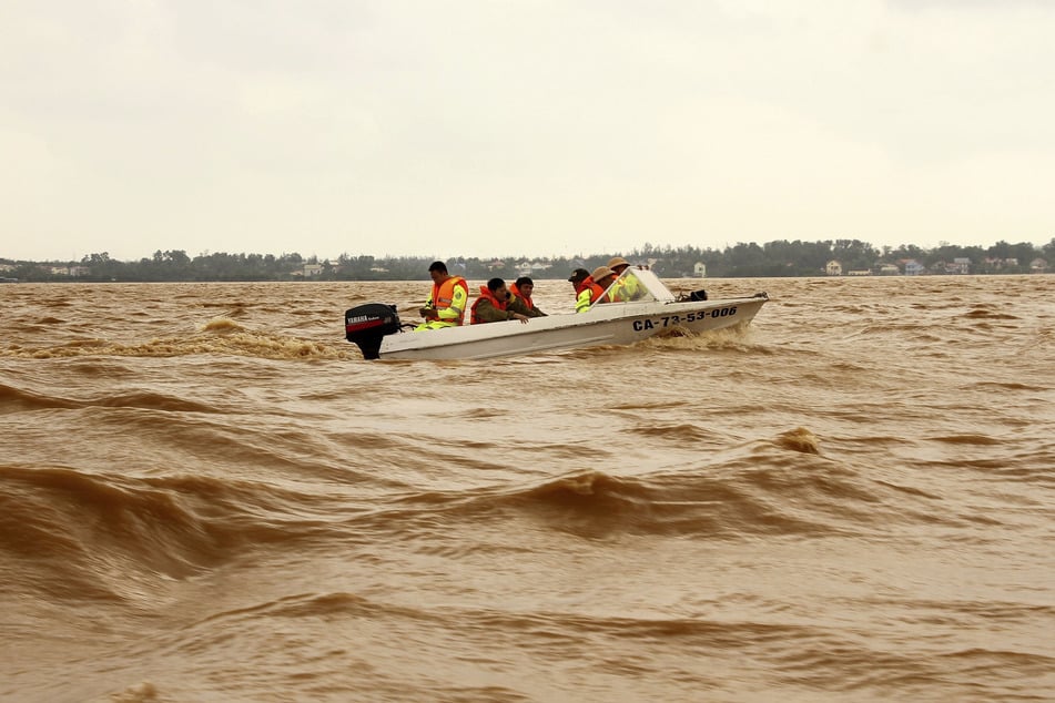 Rettungskräfte fahren mit einem Boot über ein überflutetes Gebiet bei Quang Binh.