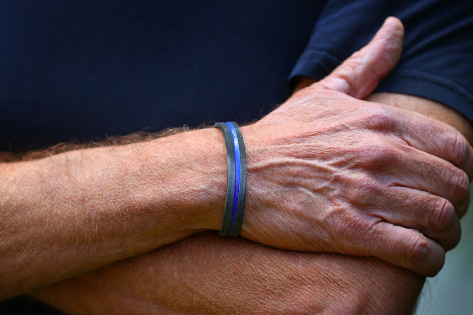 Ein Mann trägt an seinem Handgelenk ein "Thin Blue Line"-Armband. Das so unscheinbare Symbol sorgt in den Sicherheitsbehörden für Wirbel.