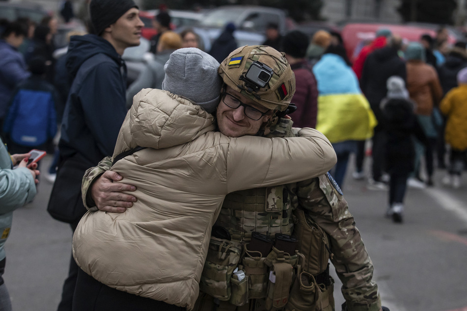 Eine Frau umarmt einen ukrainischen Offizier, als sie die Rückeroberung von Cherson feiert.