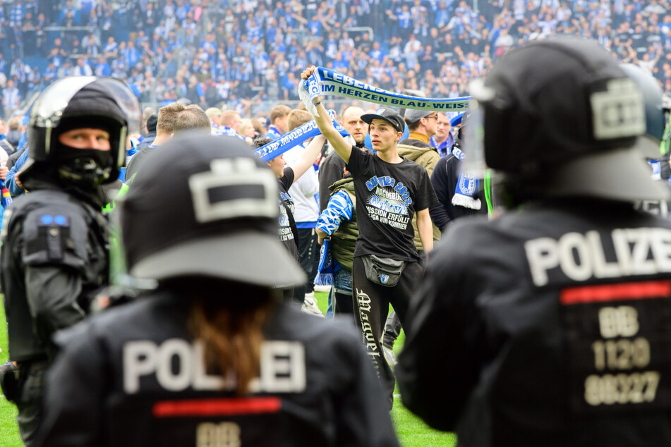 Im Spiel FCM gegen Zwickau (2022) bildete die Polizei auf dem Spielfeld eine Kette und trennte die Fans beider Vereine voneinander. (Archivbild)