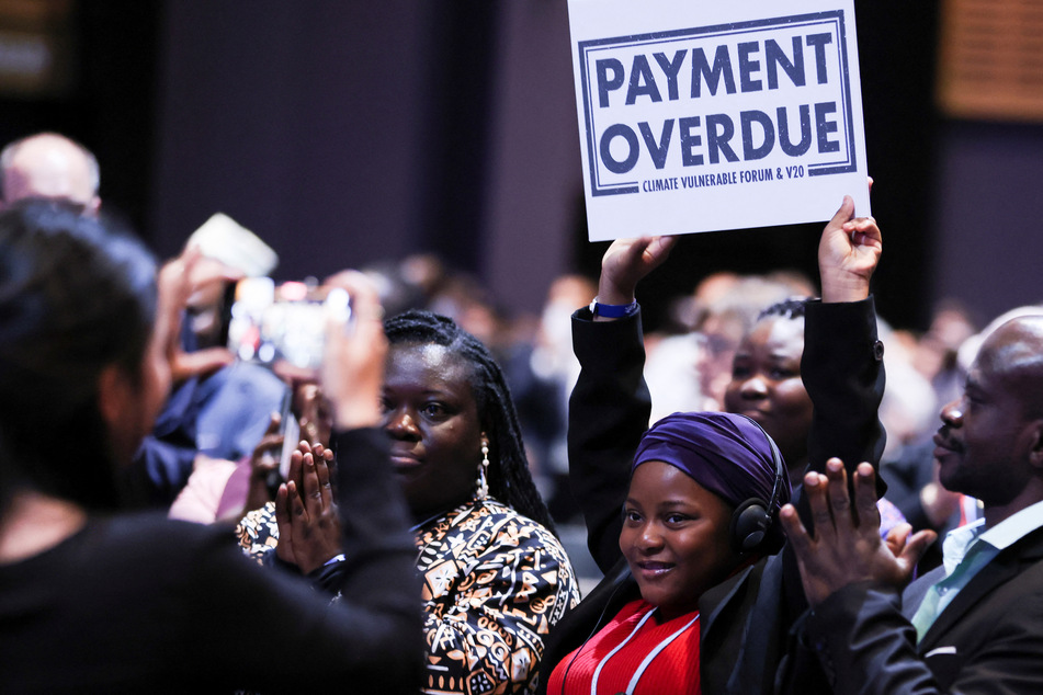 Ghanean climate activists and poet Nakeeyat Dramani Sam holds up a sign at a COP27 session.