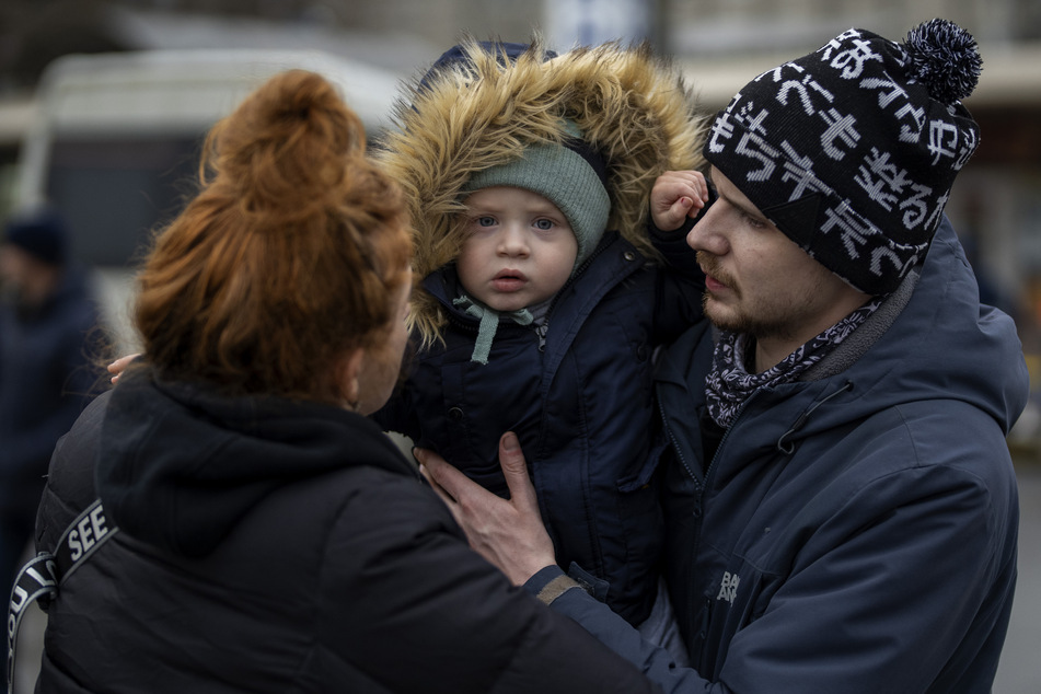 Vlad (r.) übergibt den zweijährigen Sohn Danya seiner Mutter Tatiana zum Abschied an einem Busbahnhof, bevor sie Kiew verlässt.