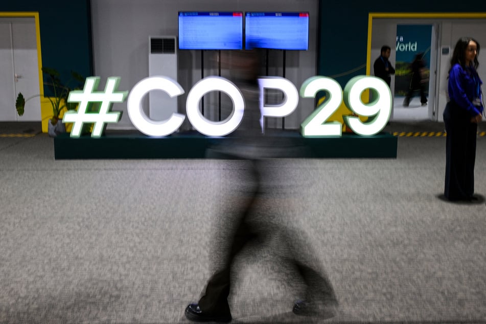 Attendees walk past the COP29 logo during the United Nations Climate Change Conference (COP29) in Baku, Azerbaijan, on Friday.