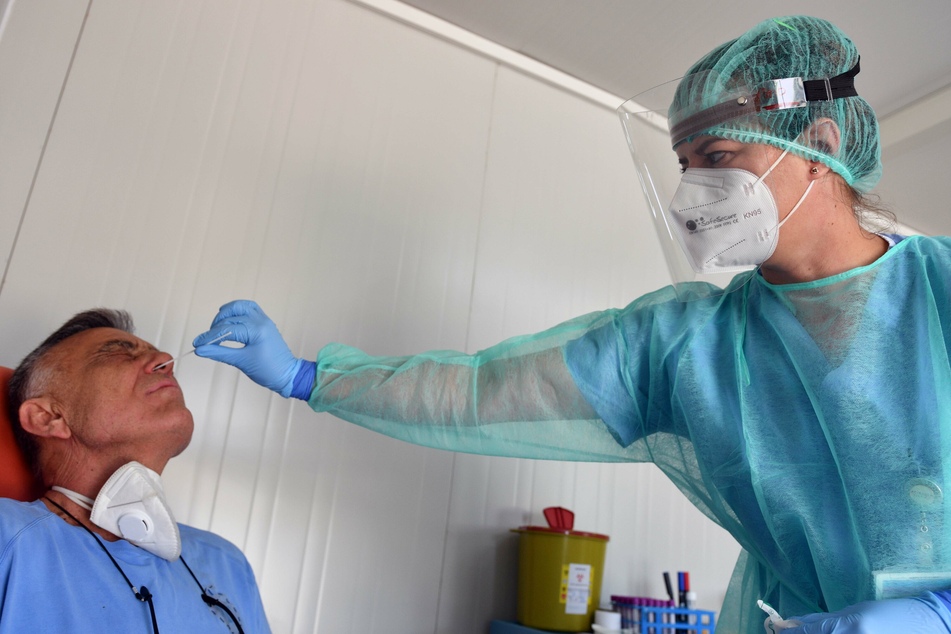 Ein medizinischer Mitarbeiter nimmt in einem Covid-19-Testzentrum einen Nasenabstrich bei einem Patienten.