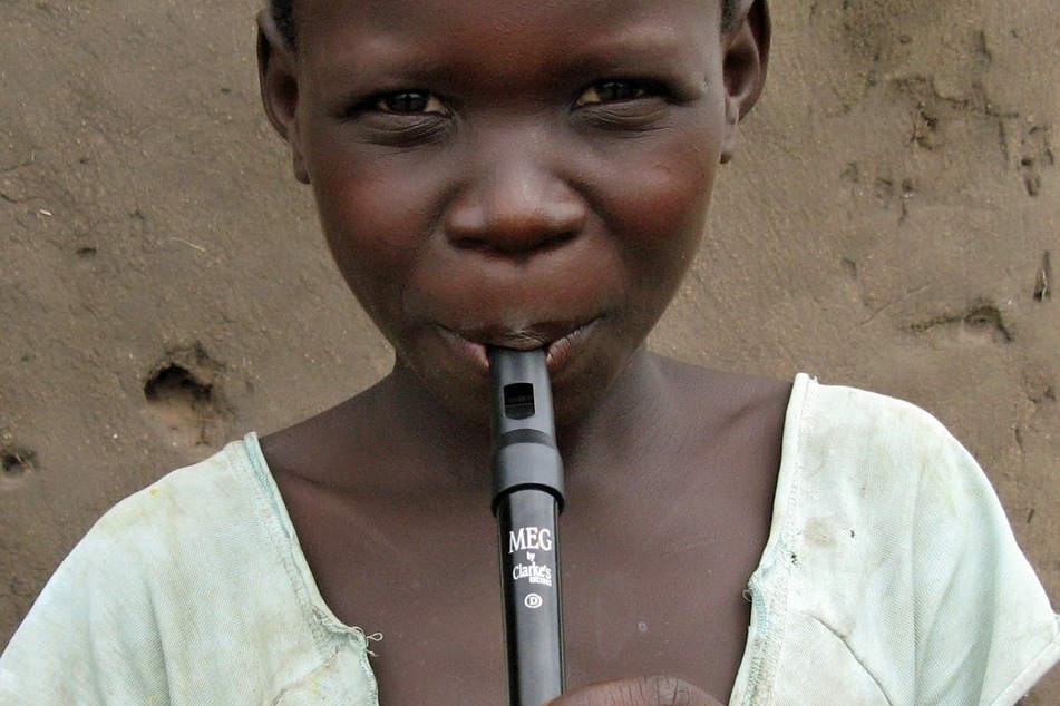 One of Shropshire's refugee students in Uganda learning the basics of music.