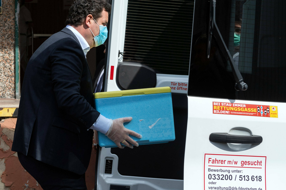 Hubertus Heil (47, SPD) nimmt aus einem Transporter eine Kiste mit Essen heraus.