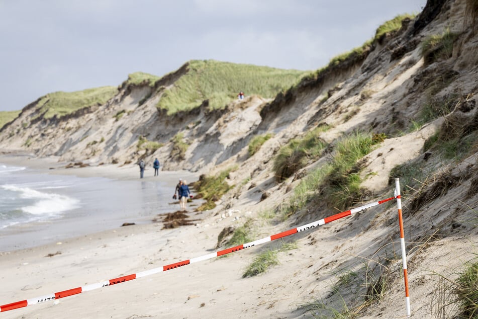 Die Jungs graben anscheinend eine Art Höhle in die Düne und lösten so einen Erdrutsch aus.