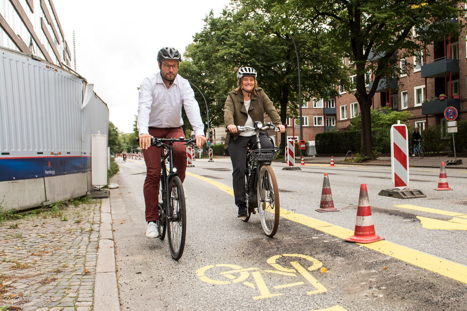 Anjes Tjarks (39, Bündnis90/Die Grünen), Hamburgs Senator für Verkehr und Mobilitätswende und Kirsten Pfaue, Koordinatorin für Mobilitätswende in der Behörde für Verkehr und Mobilitätswende (BMV) fahren im Stadtteil Rothenbaum auf einer Pop-Up-Bikelane Fahrrad.