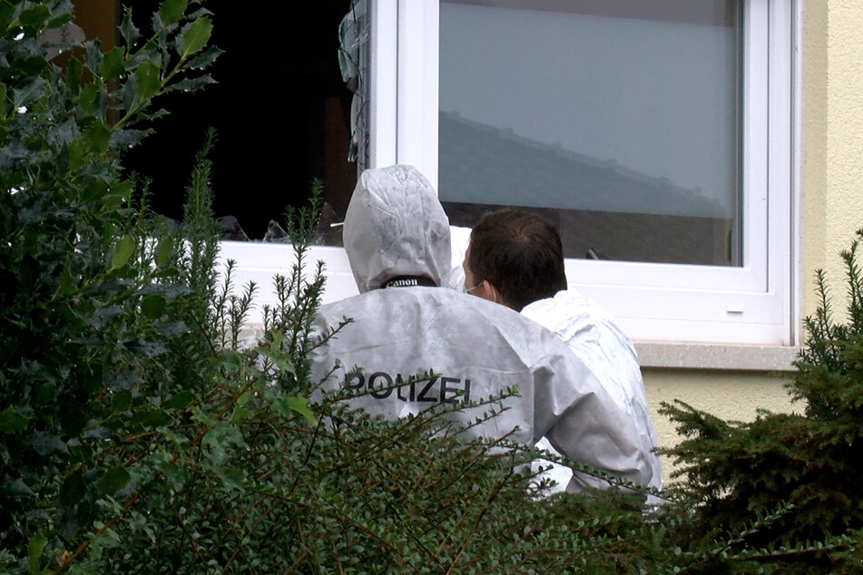 Beamte der Spurensicherung stehen vor einer eingeschlagenen Fensterscheibe im Erdgeschoss. Der 23-Jährige drang auf diesem Weg erneut in die Wohnung ein.