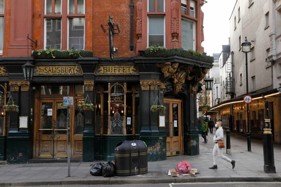 Großbritannien, London: Ein Mann geht an einem geschlossenen Pub in Covent Garden im Zentrum von London, vorbei.