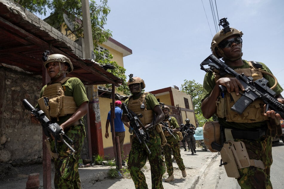 The Haitian national police's SWAT unit and Kenyan police walk to board an armored vehicle in Port-au-Prince.