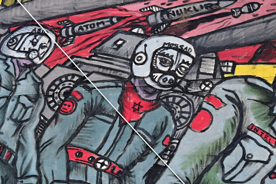 Antisemitismus-Eklat bei der documenta fifteen: Das Großgemälde des indonesischen Künstlerkollektivs Taring Padi zeigt unter anderem einen Soldaten mit Schweinsgesicht. Er trägt ein Halstuch mit einem Davidstern und einen Helm mit der Aufschrift "Mossad", der Bezeichnung des israelischen Auslandsgeheimdienstes.