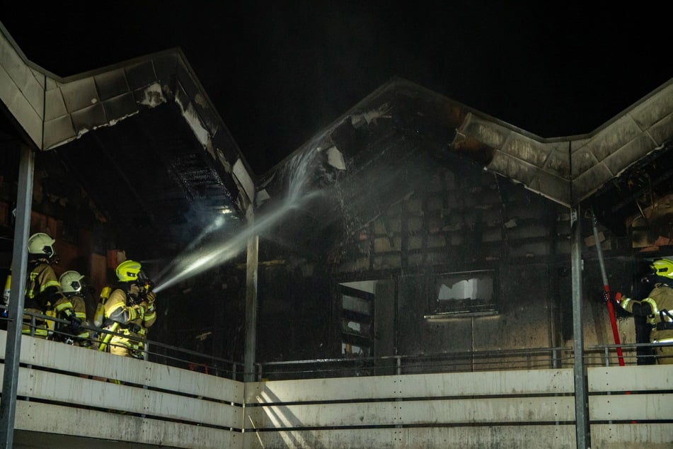 Feuerwehrleute löschen das brennende Schullandheim.