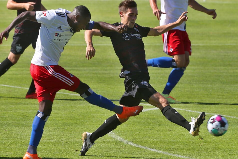 Hamburgs David Kinsombi (l.) tritt neben Philipp Klement von Stuttgart den Ball.