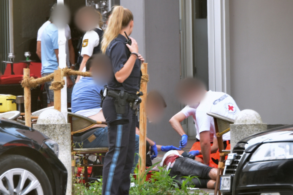 Ein Verletzter wird nach der Messerattacke in der Erdinger Innenstadt vom Rettungsdienst versorgt.