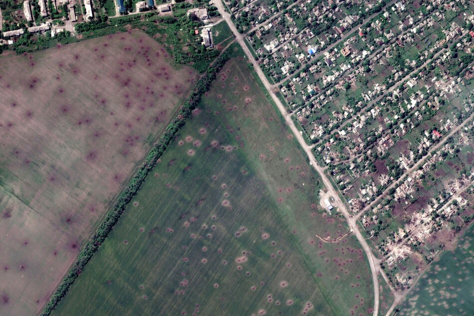 Dieses von Maxar Technologies zur Verfügung gestellte Satellitenbild zeigt einen Überblick über Artilleriekrater in Feldern und zerstörte Gebäude, die durch den jüngsten Artilleriebeschuss in Lyman, Ukraine, entstanden sind.