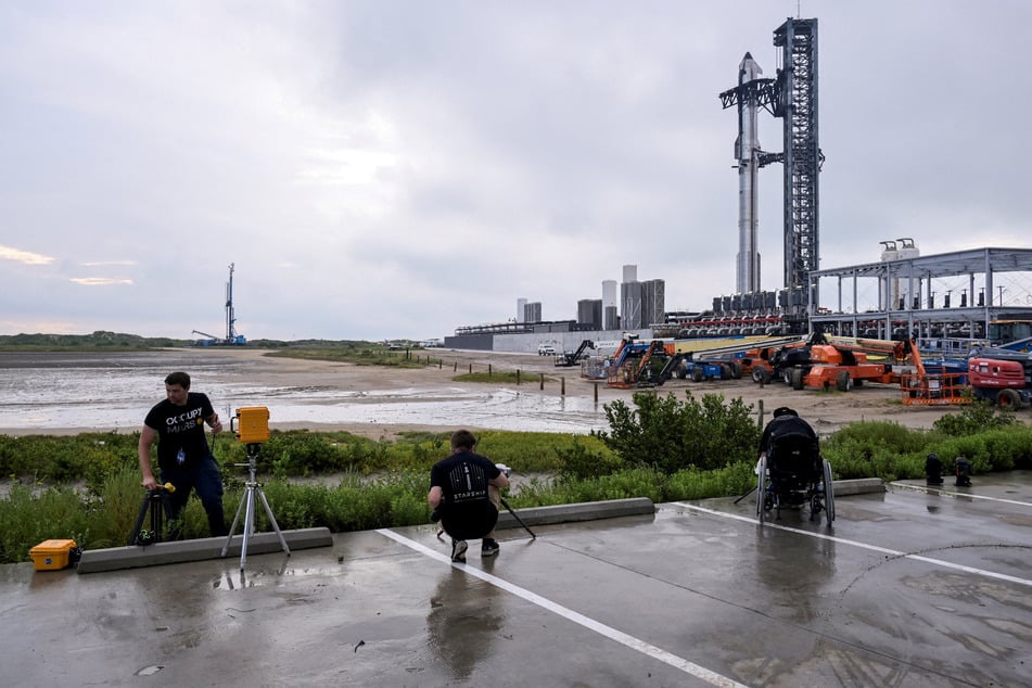 Photographers setup remote cameras for the SpaceX Starship launch on its 10th test flight at the company's complex in Texas on August 24, 2025.