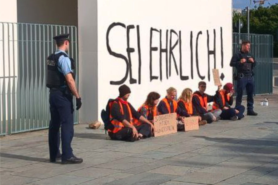 Sechs Aktivisten haben am Donnerstagmorgen "Sei ehrlich" an die Wand des Kanzleramts gepinselt.