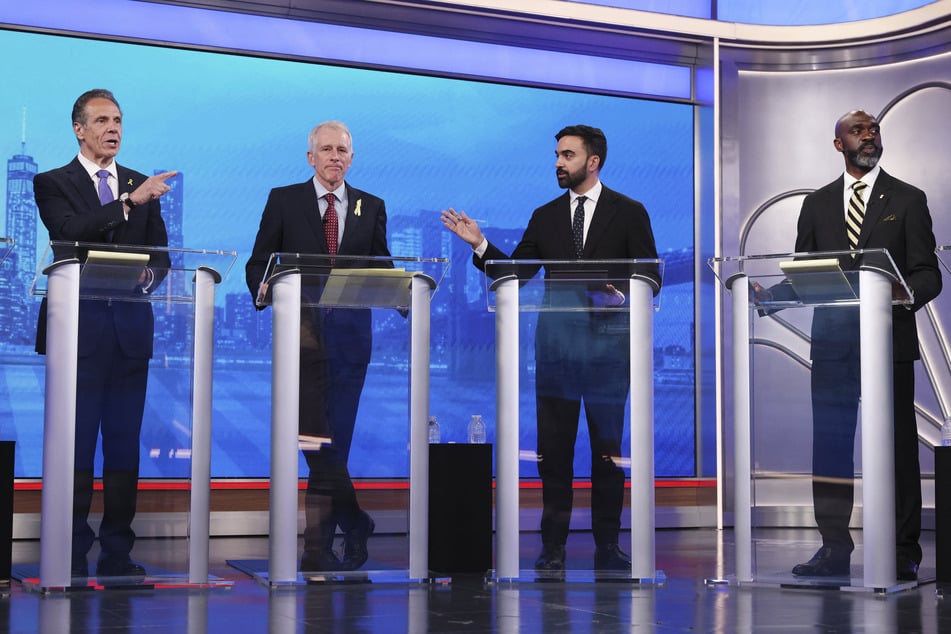 Democratic mayoral candidates Andrew Cuomo (l.) and Zohran Mamdani (second from r.) exchange in debate.