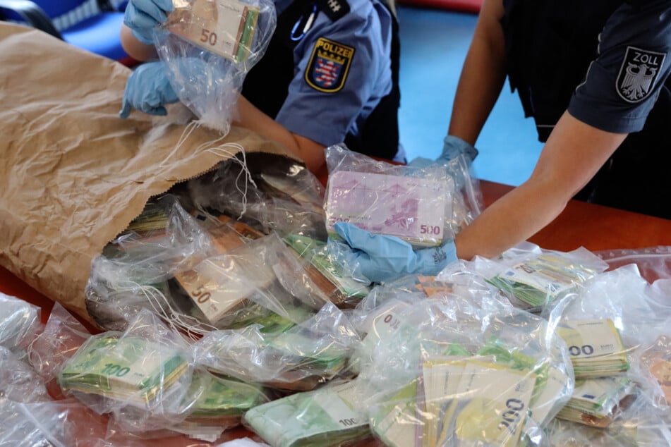 Beamtinnen beim Verpacken der Scheine: Das Geld war in Taschen und Koffern auf dem Dachboden des Tatverdächtigen entdeckt worden.