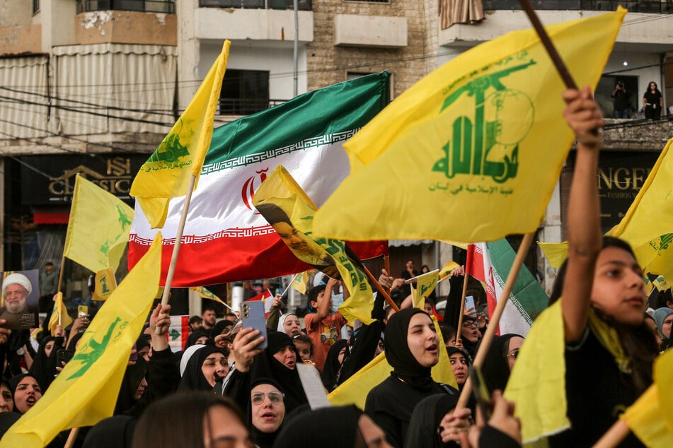 Pro-iranische Hisbollah-Anhänger schwenken die Parteifahnen während einer Zeremonie in einem südlichen Vorort von Beirut. (Archivbild)