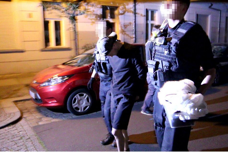 Polizisten führen einen mutmaßlichen Randalierer ab.