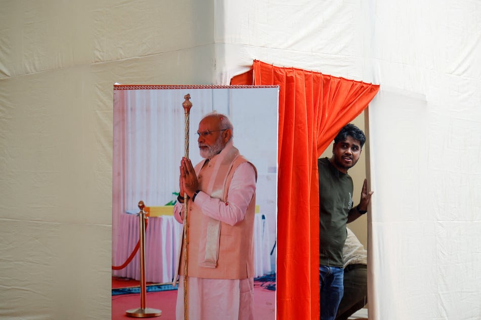 A man stands next to a picture of Indian Prime Minister Narendra Modi at the Bharatiya Janata Party headquarters in New Delhi.