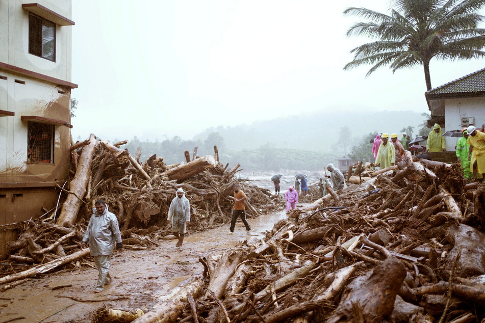 People walk past debris at a landslide site in Wayanad, in the southern state of Kerala, India.