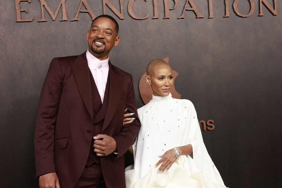 Will Smith (l) and his wife Jada Pinkett-Smith pose together on the red carpet for the premiere of his movie, Emancipation. The spouses have kept a low-profile in the months following Will striking Chris Rock at the Oscars.
