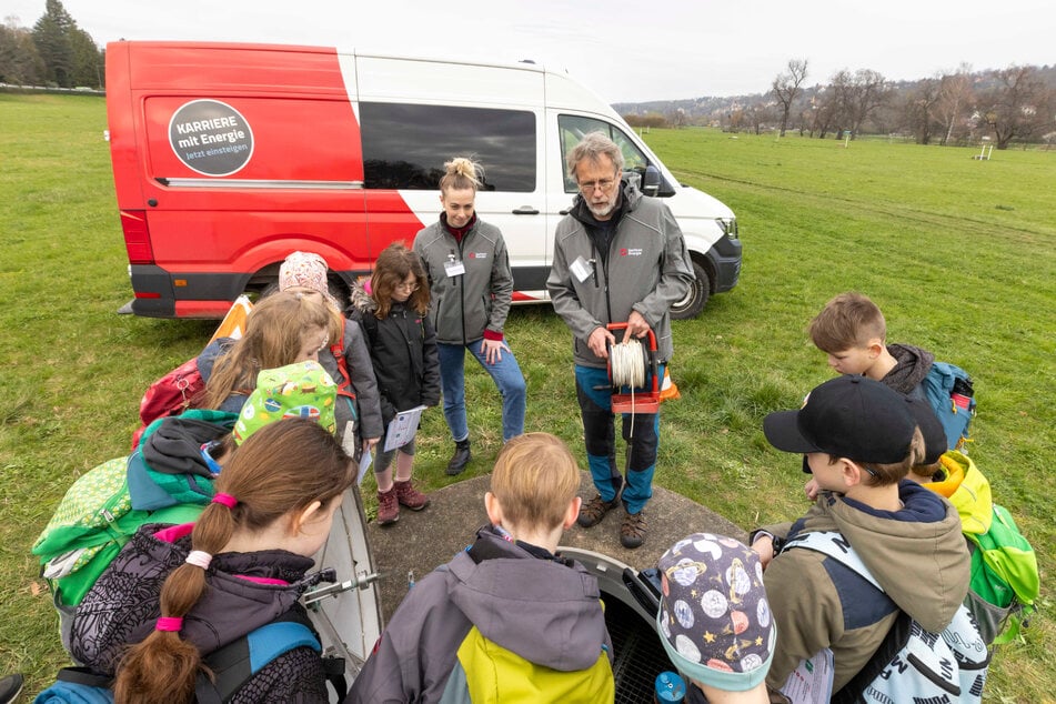 Mitten in der Wasserschutzzone erklärt Geologe Thomas Fischer (63) neugierigen Rallye-Teilnehmern, wie der Wasserstand im Brunnen gemessen wird.